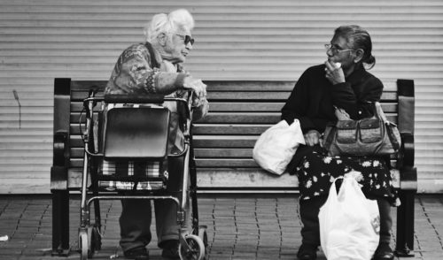 Image shows two older women talking on a bench - Listening: A Simple Way to Improve Your Relationship - Alicia Muñoz