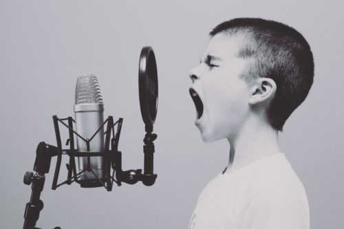 Image shows boy yelling into microphone - Listening: A Simple Way to Improve Your Relationship - Alicia Muñoz